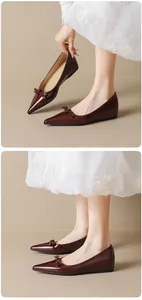 Detail of wine red pointed-toe flats with bow decoration and glossy patent leather finish