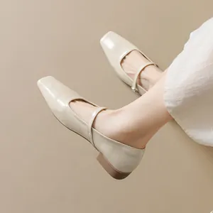 Elegant beige square-toe Mary Jane flats with strap and buckle, styled with a dress