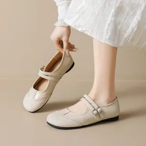 Beige Mary Jane ballet flats featuring brogue carving and double buckled straps