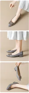 Detail of grey pointed-toe pumps featuring crystal buckle and pleated texture design
