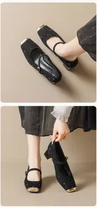 Détail de chaussures Mary Jane en daim noir avec clous dorés et bout carré rétro