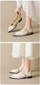 Detail of cream Mary Jane flats featuring a metallic gold cap toe and thin buckle strap