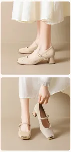 Détail de Mary Janes en daim beige avec bout carré doré et ornements cloutés