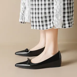 Elegant black pointed-toe Mary Jane flat shoes with bow detail and glossy patent finish