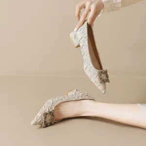 Elegant off-white pointed-toe block heel pumps with textured fabric and rhinestone buckle