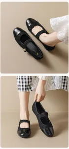 Détail de chaussure Mary Jane en tweed noir avec bout verni et boucle dorée chic