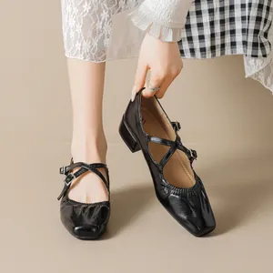 Escarpins Mary Jane noirs vintage avec brides croisées et talons épais sur fond beige