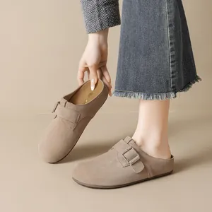 Mules de gamuza color topo con hebilla y suave plantilla de látex en fondo beige