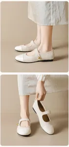 Gros plan sur des Mary Janes en tweed beige avec bout crème et boucle dorée chic