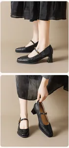 Détail de chaussures Mary Jane noires avec cuir texturé mat et boucle dorée élégante