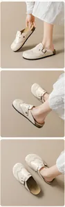 Detail of vintage brogue patterns and adjustable metal buckle on beige clogs