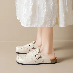 Retro cream brogue mule with cork sole and buckle detail for women shown on feet