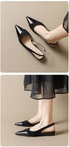 Detail view of black pointed toe slingback flats with suede and patent leather finish