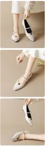 Dettaglio di ballerine Mary Jane beige con punta grigia e decoro a rosa in bronzo