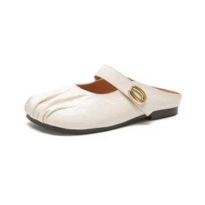 Chic cream leather pointed-toe mules with pleated texture and golden buckle strap