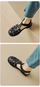 Detail of black leather woven gladiator sandals with metallic buckle and chunky sole
