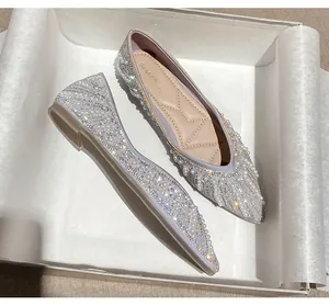 Gros plan de ballerines pointues élégantes avec perles chatoyantes et strass étincelants