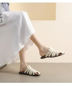 Close-up of beige woven leather flat mules with breathable cut-out design and vintage style