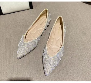 Détail de ballerines à bout pointu avec strass scintillants et décorations de perles