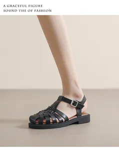 Nahaufnahme der schwarzen geflochtenen Ledersandalen mit geschlossener Kappe und Schnalle