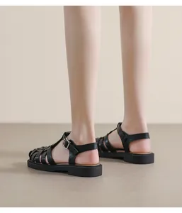 Seitenansicht schwarze geflochtene Römersandalen mit Schnalle und dicker Sohle