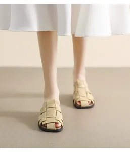 Detail shot of beige woven leather flat mules with vintage French braided strap design