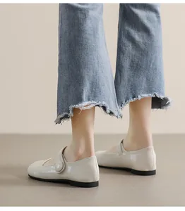 On-foot view of cream Mary Jane flat shoes with a simple strap and round toe