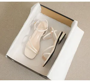 Detalle de sandalias beige de punta cuadrada con tiras cruzadas y tacón bajo dorado