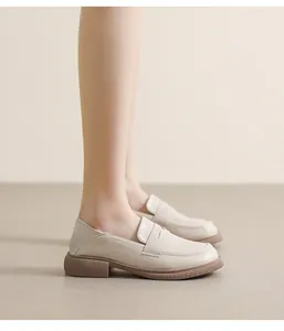 Detail view of beige leather platform loafer with thick non-slip rubber sole and stitching