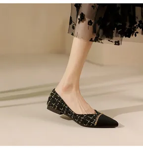 Detail of tweed pointed toe flat shoes with gold chain trim and black toe cap