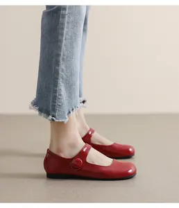 Side view of dark red Mary Jane flat shoes with round toe and buckle strap on model
