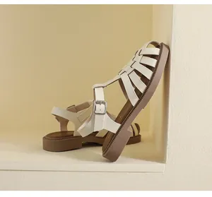 Detail von beigen gewebten Fischersandalen mit silberner Schnalle und brauner Sohle