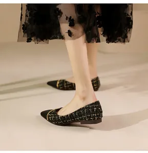 Detail of tweed pointed-toe flat shoe with elegant gold chain and black toe cap