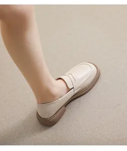 Close-up of beige leather platform loafers showing the thick tan sole and anti-slip tread