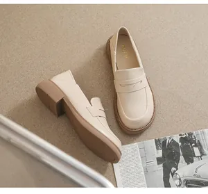 Top view of beige platform loafers with chunky heels and non-slip soles on a magazine