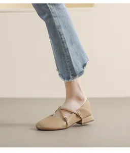 Detailaufnahme beiger Mary-Jane-Schuhe mit Kreuzriemen und goldener Schnalle