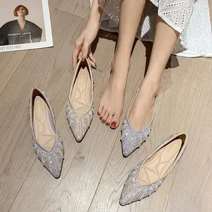 Ballerines argentées à bout pointu avec perles et strass sur parquet en bois clair