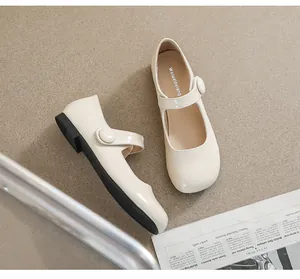 Close-up of beige Mary Jane shoes featuring a round toe and single buckle strap detail