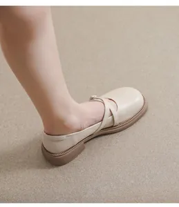 Close-up of beige Mary Jane flats with cross straps and durable rubber sole