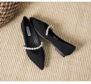 Detailed top view of black pointed toe flats with elegant pearl strap and soft fabric texture