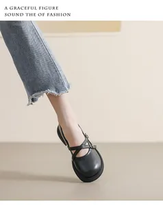Close-up of black matte Mary Jane shoes with cross straps and silver buckle detail