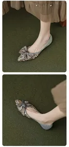 Detailed close-up of pointed-toe flat shoes featuring silver sequins and a grey silk bow