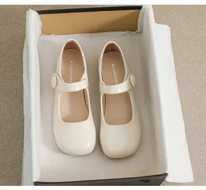 Top view of cream Mary Jane shoes with round toe and strap in a premium gift box