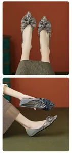 Detailed close-up of pointed flat shoes featuring glitter finish and rhinestone bow