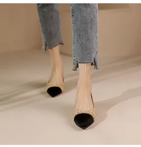 Top view of pointed-toe flat shoes with black satin finish and golden woven texture