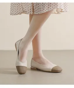 Detail of square-toe flat shoes featuring beige body and textured brown cap toe