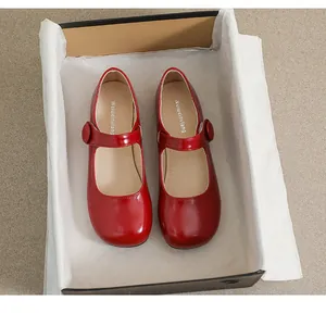 Detailed top view of red patent leather Mary Jane shoes in a black gift box