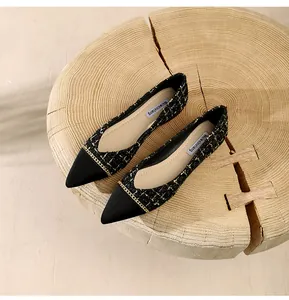 Detail of tweed pointed-toe flats with gold chain accent and soft black splicing