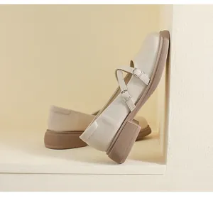 Detail of beige platform Mary Janes with silver buckles and textured brown rubber soles
