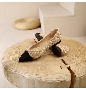 Detailed close-up of pointed-toe tweed flats with black toe cap and gold chain accent